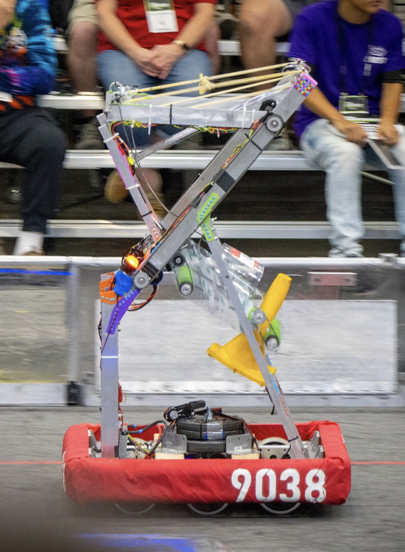 Cinematic shot of a large barebones robot with a red bumper carrying a yellow cone